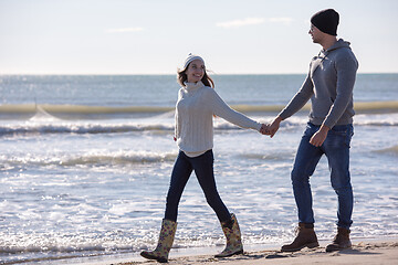 Image showing Loving young couple on a beach at autumn sunny day