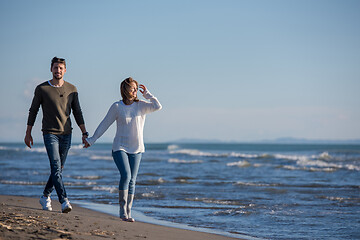 Image showing Loving young couple on a beach at autumn sunny day