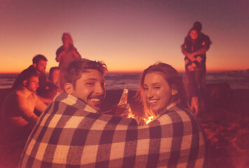 Image showing Couple enjoying with friends at sunset on the beach