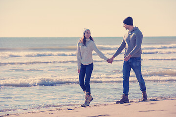 Image showing Loving young couple on a beach at autumn sunny day