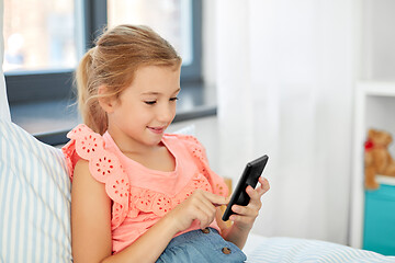 Image showing girl using smartphone sitting on bed at home