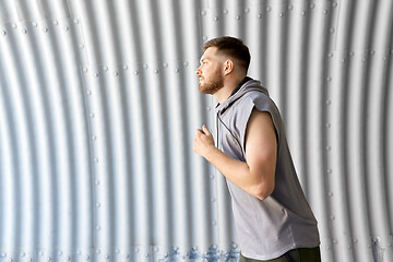 Image showing sporty young man running in tunnel