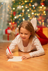 Image showing smiling girl writing christmas wish list at home