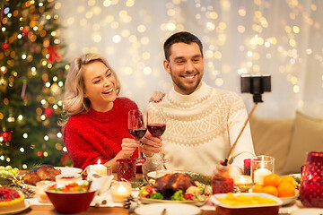 Image showing happy couple taking selfie at christmas dinner