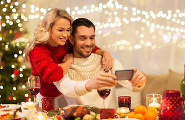 Image showing happy couple taking selfie at christmas dinner