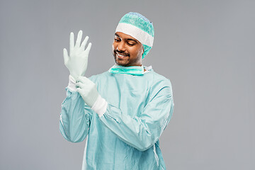 Image showing indian male doctor or surgeon putting glove on