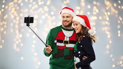 Image showing happy couple in christmas sweaters taking selfie