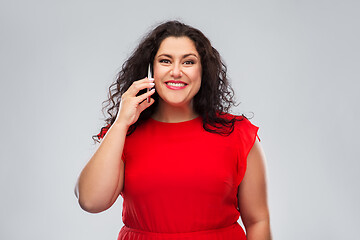 Image showing smiling woman in red dress calling on smartphone