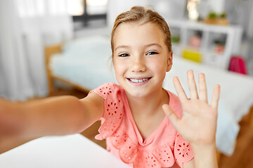 Image showing happy girl taking selfie and waving hand at home