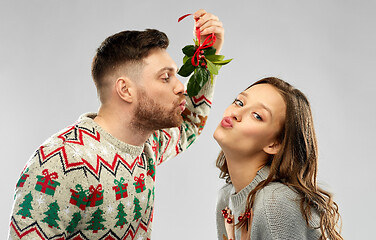 Image showing happy couple kissing under the mistletoe