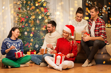 Image showing friends celebrating christmas and opening presents