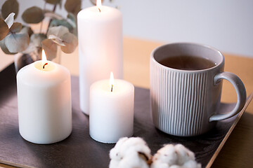 Image showing candles, tea and branches of eucalyptus on table