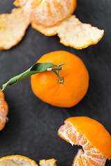 Image showing close up of peeled mandarins on slate table top