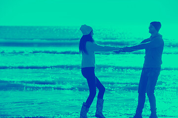 Image showing Loving young couple on a beach at autumn sunny day