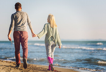 Image showing Loving young couple on a beach at autumn sunny day