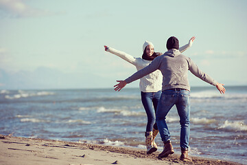 Image showing Loving young couple on a beach at autumn sunny day