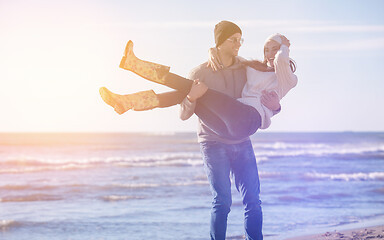 Image showing Loving young couple on a beach at autumn sunny day