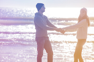 Image showing Loving young couple on a beach at autumn sunny day