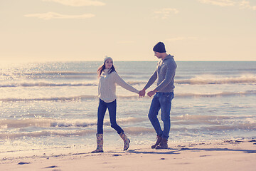 Image showing Loving young couple on a beach at autumn sunny day