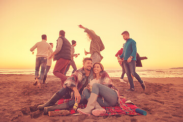 Image showing Couple enjoying with friends at sunset on the beach