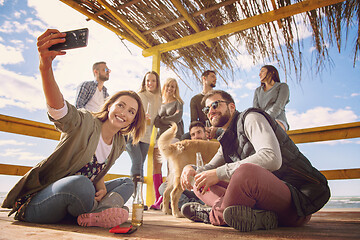 Image showing Group of friends having fun on autumn day at beach