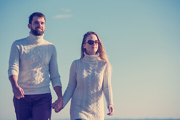 Image showing Loving young couple on a beach at autumn sunny day