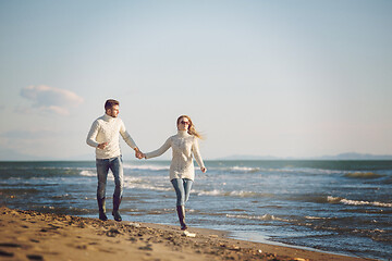 Image showing Loving young couple on a beach at autumn sunny day