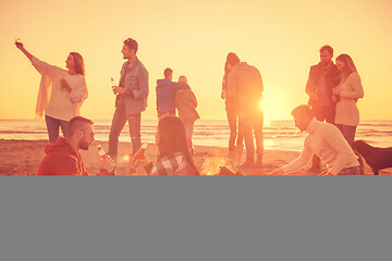 Image showing Couple enjoying with friends at sunset on the beach