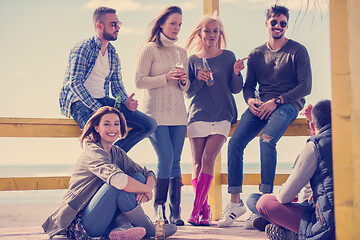 Image showing Group of friends having fun on autumn day at beach