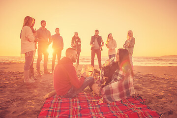 Image showing Couple enjoying with friends at sunset on the beach