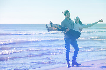 Image showing Loving young couple on a beach at autumn sunny day