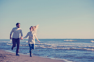 Image showing Loving young couple on a beach at autumn sunny day