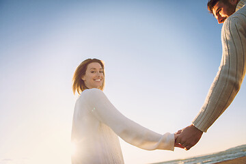 Image showing Loving young couple on a beach at autumn sunny day