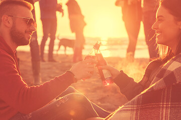 Image showing Couple enjoying with friends at sunset on the beach