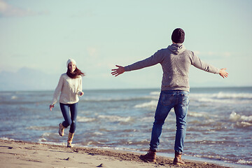 Image showing Loving young couple on a beach at autumn sunny day