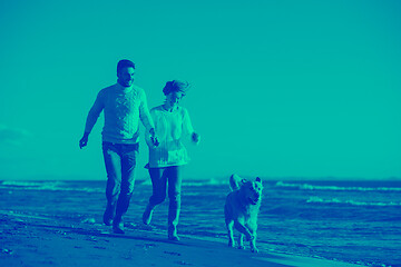 Image showing couple with dog having fun on beach on autmun day