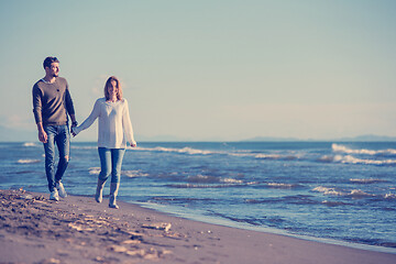 Image showing Loving young couple on a beach at autumn sunny day