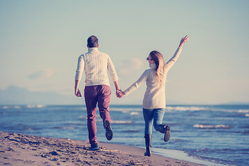 Image showing Loving young couple on a beach at autumn sunny day