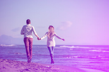 Image showing Loving young couple on a beach at autumn sunny day