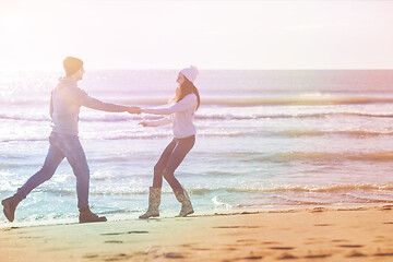 Image showing Loving young couple on a beach at autumn sunny day