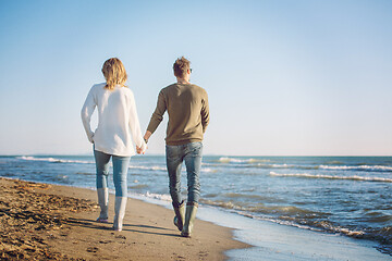 Image showing Loving young couple on a beach at autumn sunny day