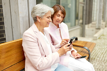 Image showing happy senior women with smartphones in city