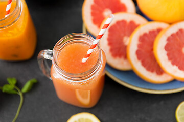 Image showing mason jar glass of fruit juice with paper straw