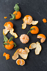 Image showing close up of peeled mandarins on slate table top