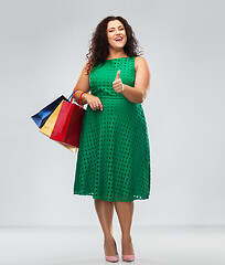 Image showing happy woman with shopping bags showing thumbs up