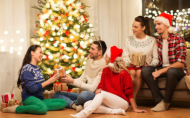 Image showing friends celebrating christmas and giving presents