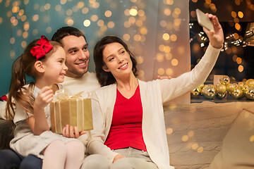 Image showing happy family with christmas present at home