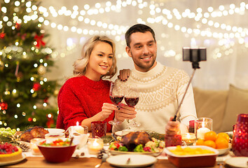 Image showing couple taking picture by selfie stick at christmas