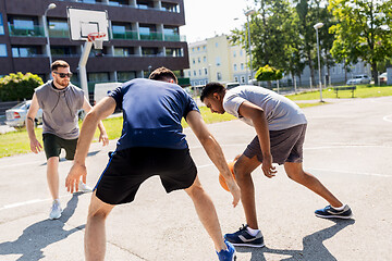 Image showing group of male friends playing street basketball