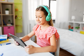 Image showing girl in headphones with tablet computer at home